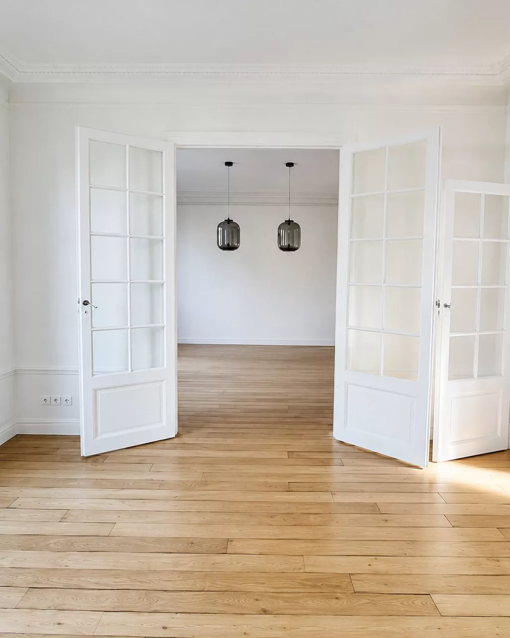 Enfilade de portes vitrées sur parquet chevron