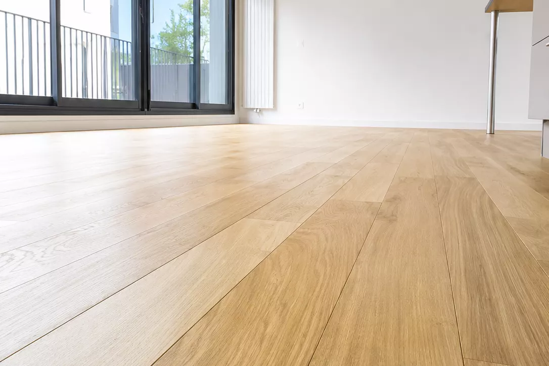Pièce lumineuse au parquet en bois clair, après intervention